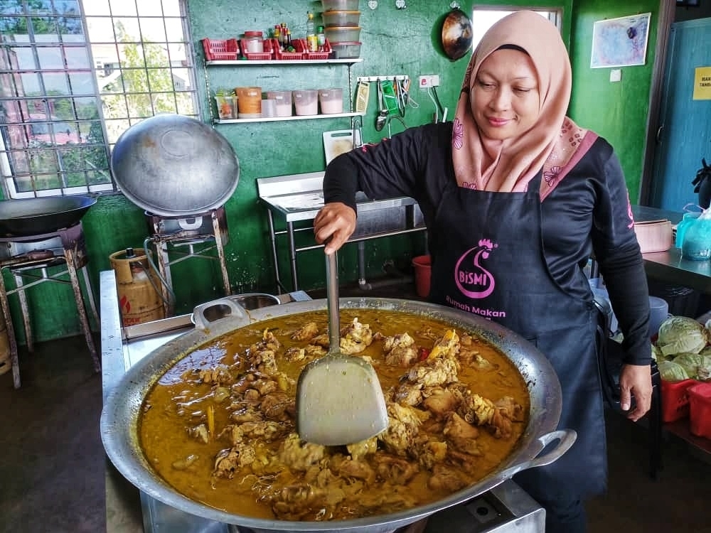 Tukang masak, Azura Zainol menyediakan masakan lemak cili padi ayam untuk dinikmati pengunjung RMP.
