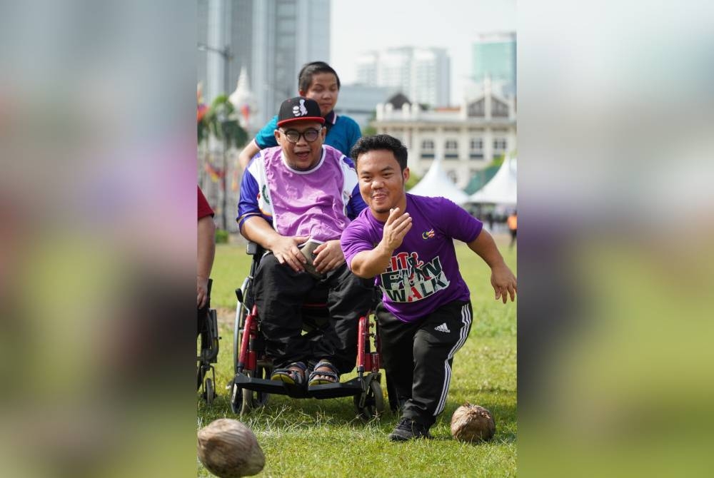 Salah seorang peserta mengambil bahagian dalam acara boling kelapa pada Sukan Perpaduan sempena Program Santai@Kuala Lumpur 2023.