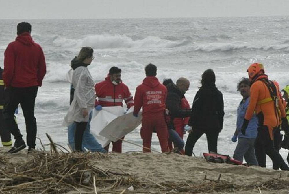 Anggota penyelamat sedang membawa keluar mayat pendatang yang ditemui di pantai di wilayah wilayah Calabria, Itali. - Foto Agensi