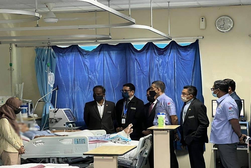 Sivakumar (kanan) melawat Muhammad Hafizi di Hospital Sungai Buloh pada Selasa.