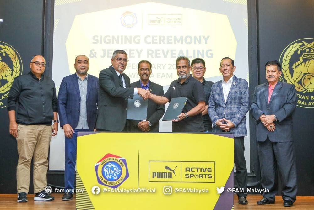 Noor Azman (depan, kiri) dan Murugeson bersalaman sempena majlis menandatangani perjanjian penajaan jersi Puma buat skuad Projek FAM-MSN di Kelana Jaya, Petaling Jaya pada Selasa. - Foto FAM