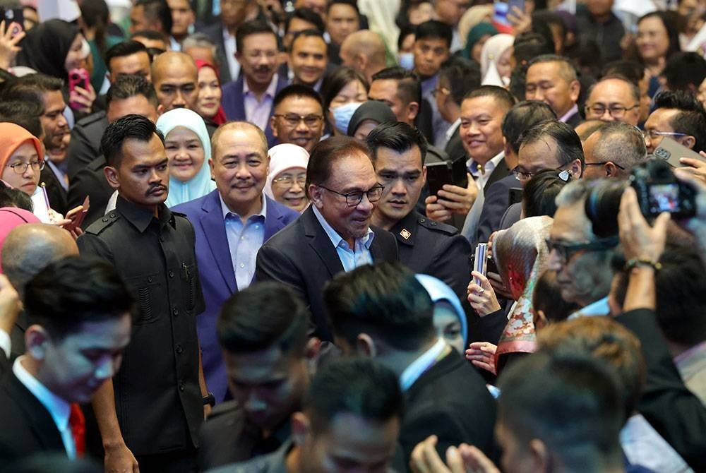 Anwar (tengah) beramah mesra bersama para penjawat awam sewaktu tiba pada majlis amanat Perdana Menteri kepada Penjawat Awam negeri dan Persekutuan. -Foto Bernama