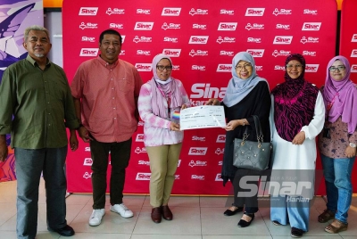 Latiffah (tiga dari kanan) menyerahkan sumbangan kepada Pengerusi Kumpulan Karangkraf, Firdaus Hussamuddin (tiga dari kiri) di Kompleks Kumpulan Karangkraf pada Isnin.