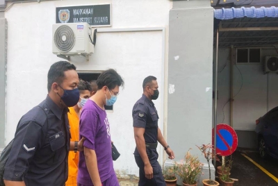 Tertuduh (dua dari kiri) tiba di Mahkamah Majistret Kluang, pada Selasa.