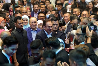 Anwar (tengah) beramah mesra bersama para penjawat awam sewaktu tiba pada majlis amanat Perdana Menteri kepada Penjawat Awam negeri dan Persekutuan. -Foto Bernama