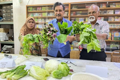 Mohideen (tengah) menunjukkan jenis sayuran yang mengandungi peratusan racun makhluk perosak pada sidang akhbar pada Rabu.