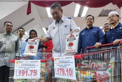 Salahuddin (tengah) melihat perbezaan barangan pada harga asal dan harga melalui kempen Jualan Rahmah.