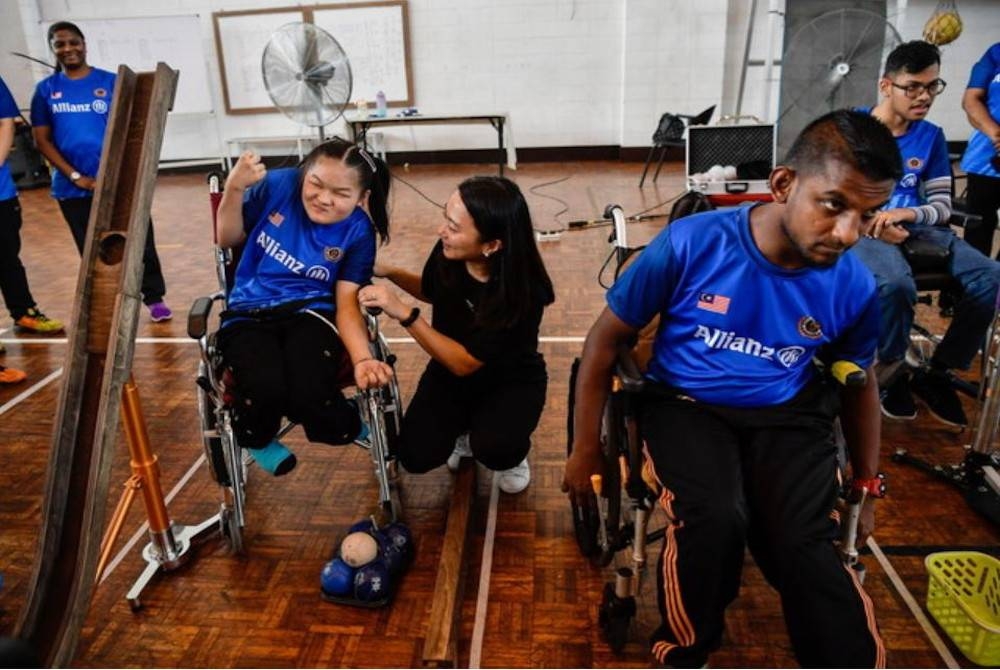 Hannah (tengah) beramah mesra bersama atlet paralimpik negara semasa melakukan lawatan kerja ke Pusat Kecemerlangan Sukan Paralimpik. - Foto Bernama