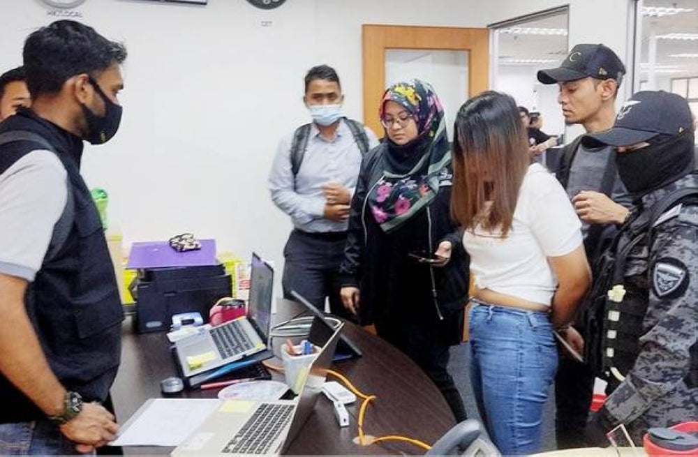 Antara ahli sindiket penipuan (tiga dari kanan) yang ditahan di sebuah boiler room di sekitar Lembah Klang, baru-baru ini.
