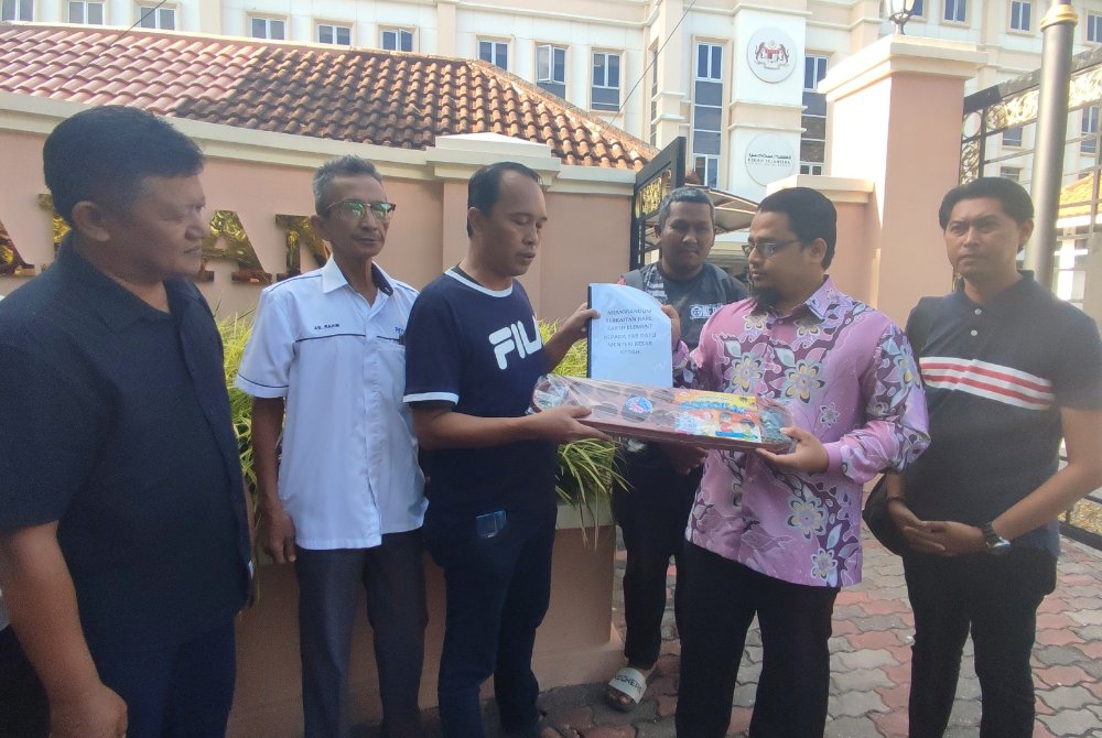 Ahmad Kamaruddin (tiga kiri) menyerahkan memorandum berkaitan unsur nadir bumi ataupun Rare Earth Element (REE) kepada Ku Abdul Muhyi (dua, kanan) di hadapan Wisma Darul Aman, di sini, pada Khamis.