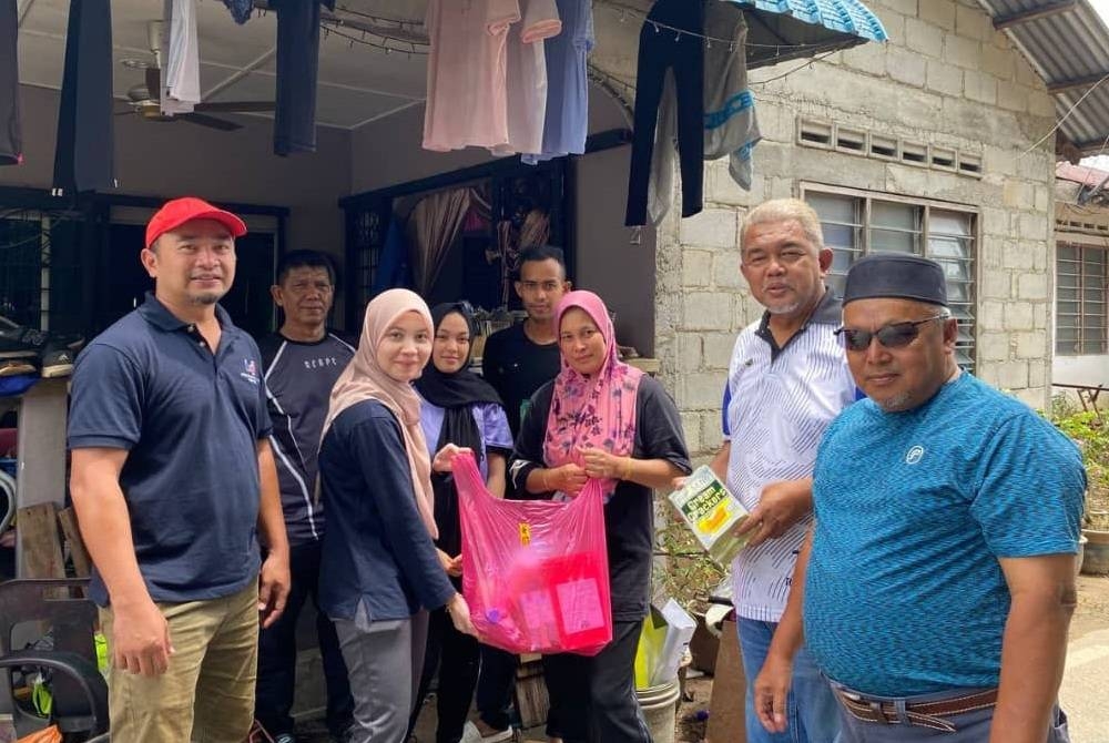 Hashim (dua dari kanan) menyampaikan sumbangan kepada penduduk Kampung Bentong.