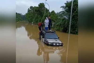 Tangkap layar rakaman video tiga individu termasuk Suhaimizan yang terkandas di lokasi. - Foto ihsan penduduk