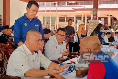 Saarani (kiri) mendengar aduan penduduk sempena Program Mesra Hari Bertemu Pelanggan di Arena Square Parit pada Khamis.