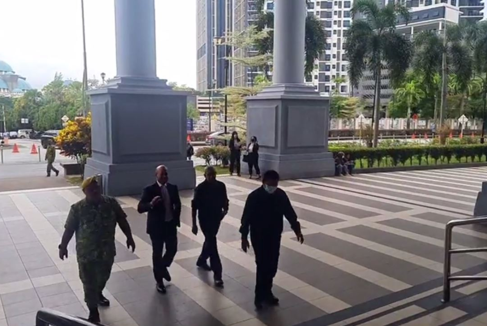 Arul Kanda (dua dari kiri) tiba di Mahkamah Tinggi Kuala Lumpur jam 9.13 pagi tadi.