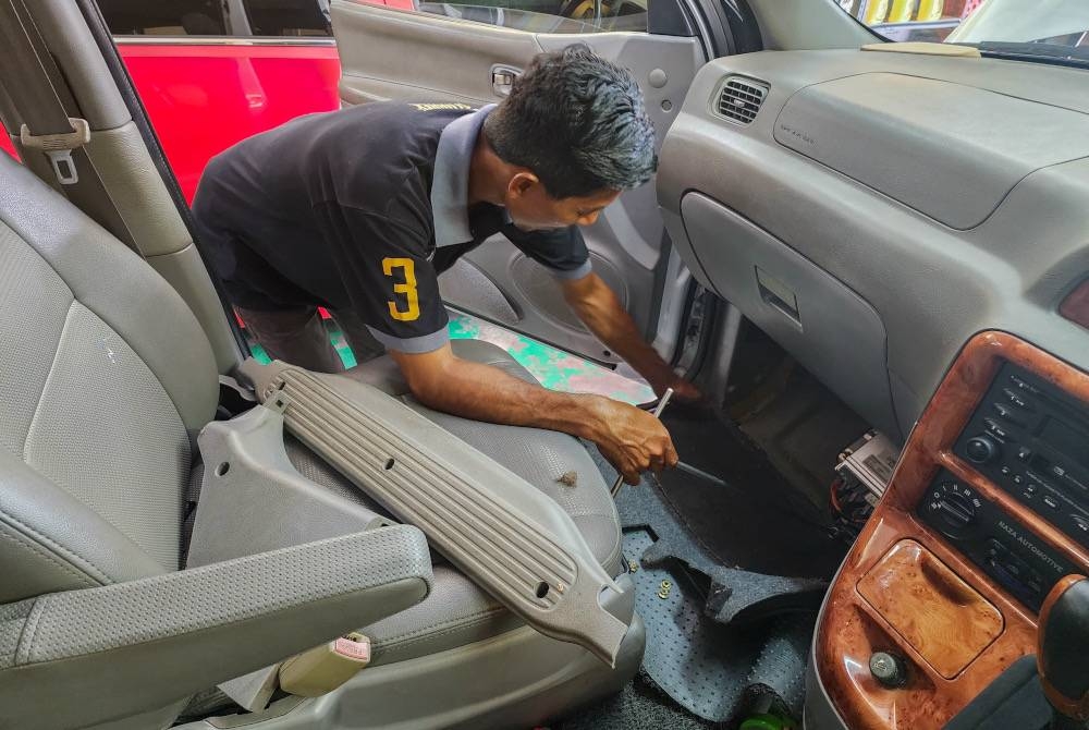 Mohammad Naim menawarkan perkhidmatan percuma kepada mangsa banjir bagi menghidupkan kembali enjin kereta sekali gus membantu meringankan beban mereka akibat bencana itu. - Foto Bernama