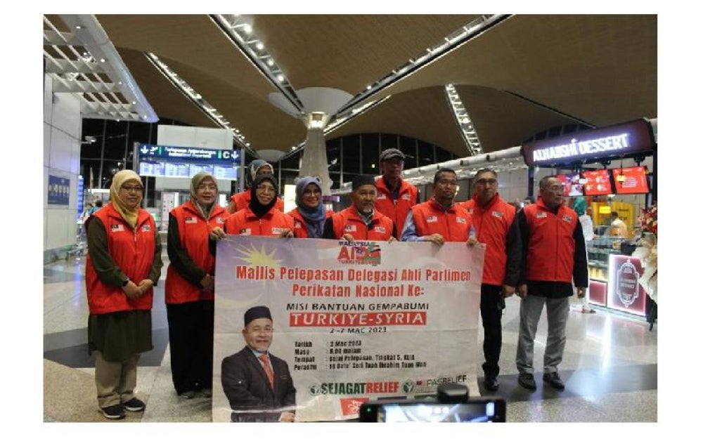 Tuan Ibrahim (tengah) bergambar bersama ahli parlimen PN dan sukarelawan di KLIA sebelum berlepas ke Turkiye.