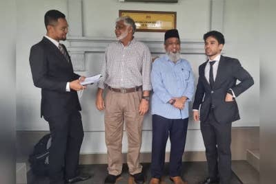 Gulam Rusol (dua dari kanan) dan Kamaruzzaman (dua dari kiri) ditemani peguam masing-masing ketika ditemui di luar Mahkamah Sesyen di sini pada Jumaat.