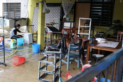 Penduduk setempat dilihat mula melakukan kerja-kerja pembersihan di kediaman mereka selepas banjir surut ketika tinjauan di Taman Pinggiran Sungai Kelamah, Gemas, Negeri Sembilan. - Foto Bernama