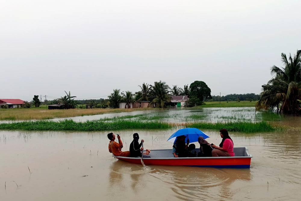 Keadaan sebahagian rumah dan tanaman sawah padi penduduk di Parit Sidang Seman Benteng Sungai Rambai, Jasin, Melaka yang telah mula dinaiki air ketika tinjauan pada Sabtu. - Foto: Bernama
