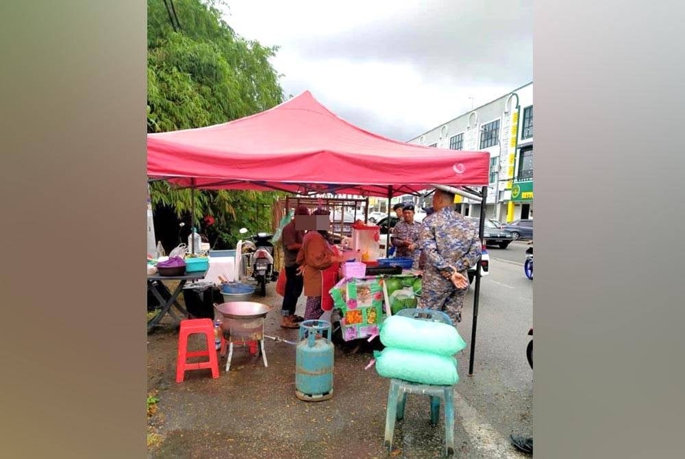 Anggota penguat kuasa memberi teguran kepada peniaga. - Foto MPKB-BRI