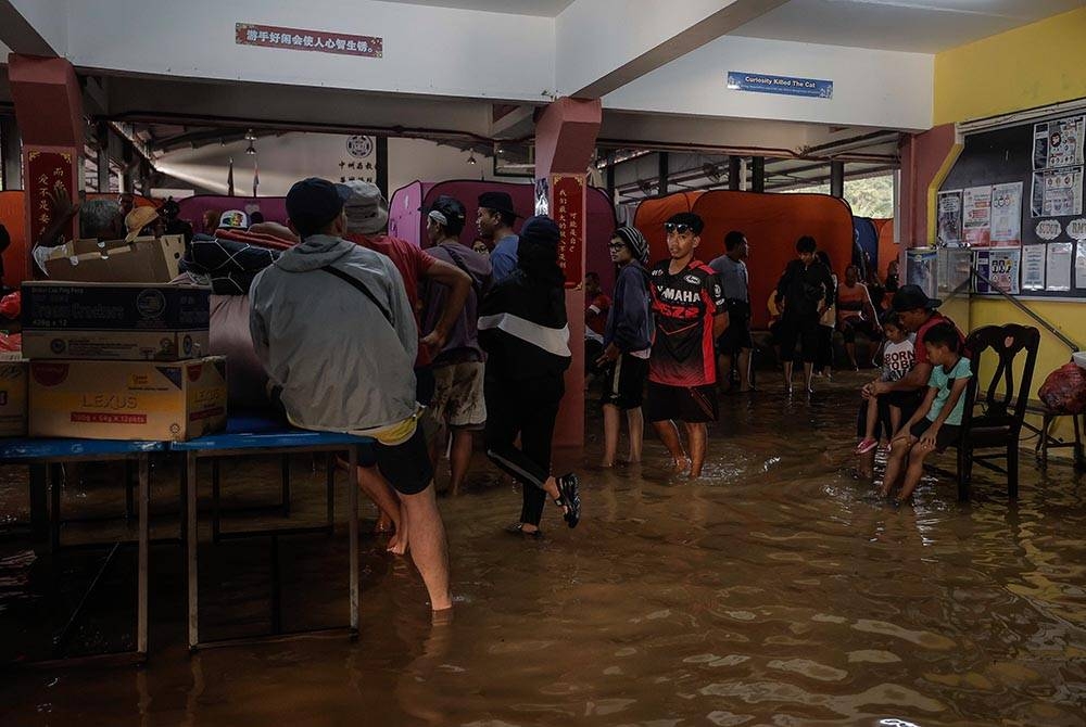 Mangsa banjir yang ditempatkan di PPS di Sekolah Jenis Kebangsaan (C) Chong Hwa Sri Medan mula keluar selepas PPS itu dinaiki air. - Foto Bernama