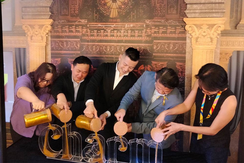 Pengarah Julie's biskut, Tzy Horng Sai (tengah) ketika menuang 'simbolik bagi pelancaran biskut baharu di majlis 'Me, Myself and Charm', APW Bangsar, di sini, pada Jumaat.