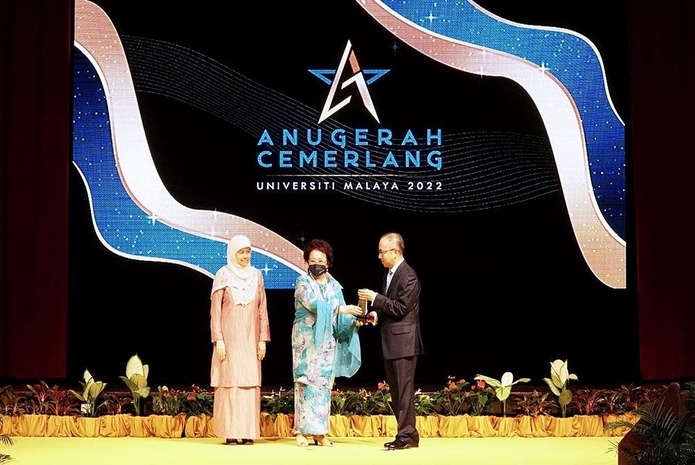 Toh Puan Dr Aisyah (tengah) menyampaikan Anugerah Rakan Kongsi Cemerlang 2022 kepada Andrian Ong dan disaksikan oleh Timbalan Naib Canselor, Penyelidikan dan Inovasi, Profesor Dr. Shaliza Ibrahim.