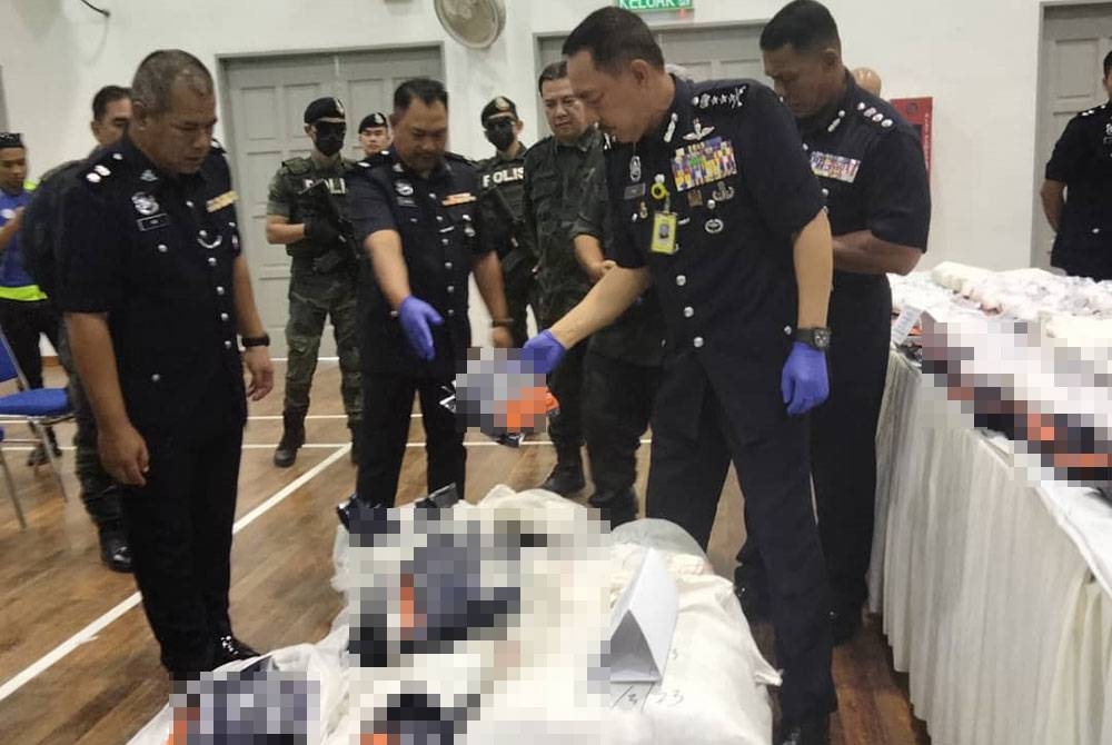 Muhamad Zaki (kanan) menunjukkan dadah yang dibungkus dalam pembalut jenama kopi.