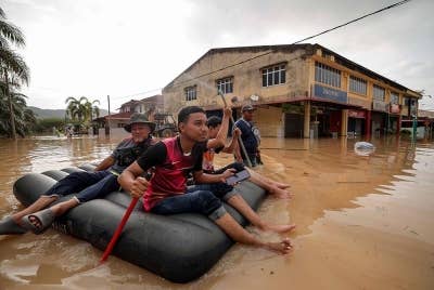 Beberapa penduduk setempat meredah banjir dari kediaman ke PPS ketika tinjauan di Seri Medan Batu Pahat pada Isnin. - Foto BERNAMA