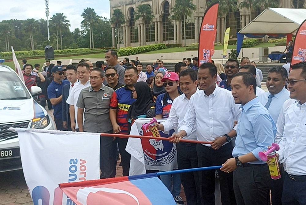 Onn Hafiz (dua dari kanan) melepaskan sukarelawan konvoi pasca banjir Johor di Dataran Mahkota Kota Iskandar pada Rabu.