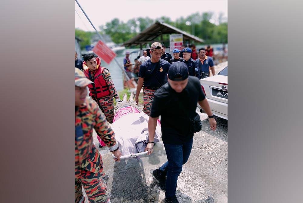 Anggota bomba mengangkat mayat seorang lelaki warga emas yang ditemukan lemas di Kampung Kong Kong Laut pada Rabu.