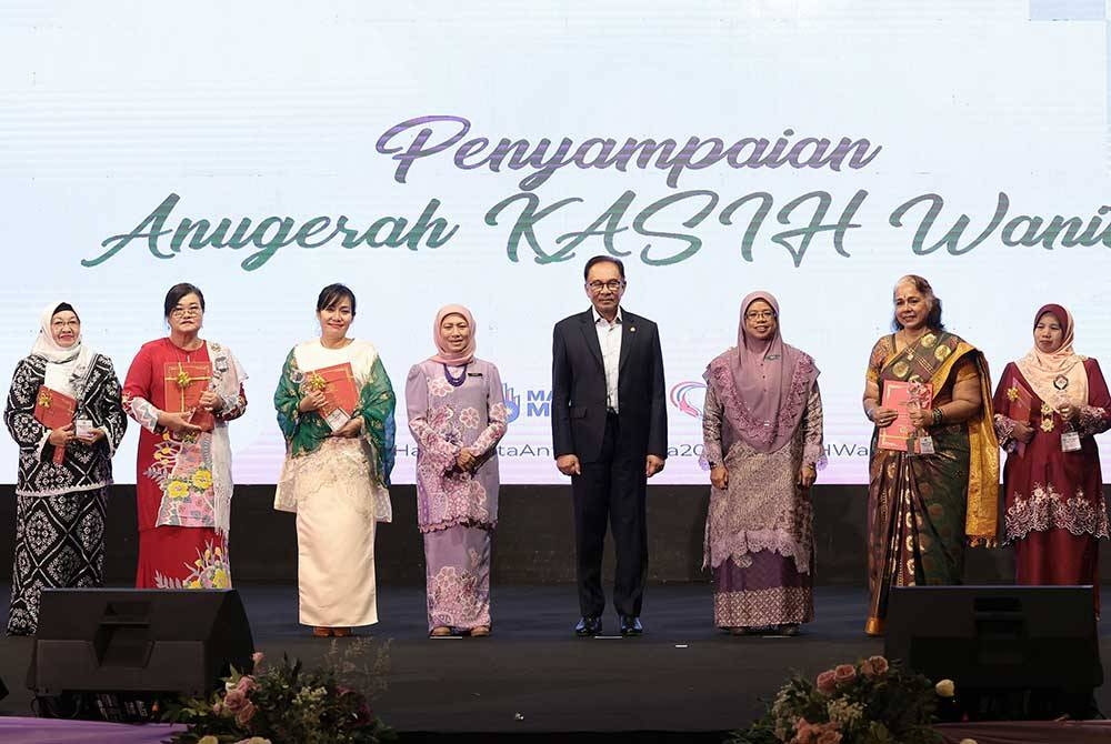 Anwar (empat, kanan) bergambar bersama lima penerima Anugerah Kasih pada sambutan Hari Wanita Antarabangsa 2023 di Dewan Perdana Felda pada Rabu. - Foto Bernama