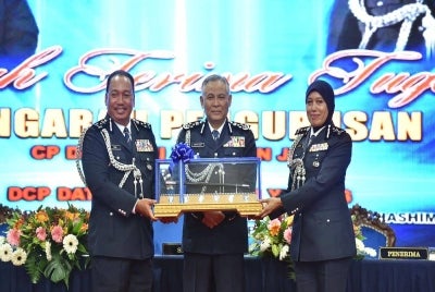 Zaini (kiri) menyerahkan tongkat kepada Nerita pada majlis serah terima tugas Pengarah Pengurusan di Pulapol Kuala Lumpur, pada Rabu.