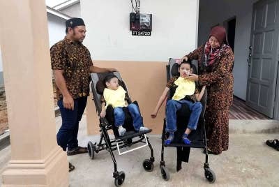 Syamsiah (kanan) dan suami, Mansor di samping dua anak mereka ketika majlis perasmian dan penyerahan rumah di Kampung Padang Mengkuang, Bukit Payong di Marang.