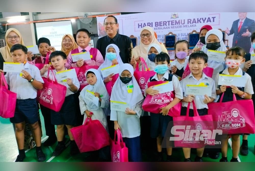 Cahaya (empat dari kiri) bergambar bersama sebahagian penerima sumbangan persekolahan di Kompleks Japerun Pengkalan Batu pada Khamis.