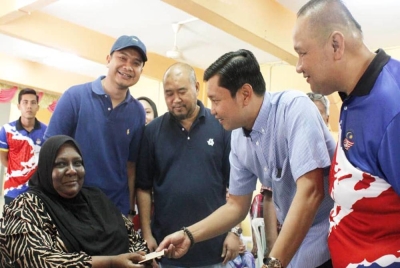 Mohamad Ghazali (dua dari kiri) dan Bastien (tengah) menyerahkan sumbangan YBR kepada mangsa banjir di Dewan Pertubuhan Kebajikan Anak Yatim Islam, Gemereh Segamat, Johor.