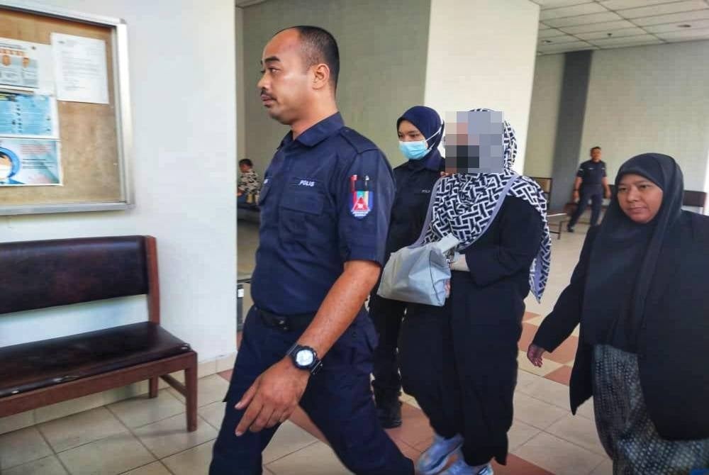 Tertuduh (dua kanan) didakwa di Mahkamah Majistret di sini pada Jumaat.