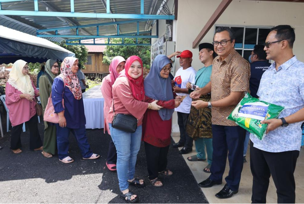 Ahmad Feizal (au centre) et Mohd Fuad (à droite) apportent de l'aide aux victimes des inondations au bureau du député de Bukit Naning, à Muar.