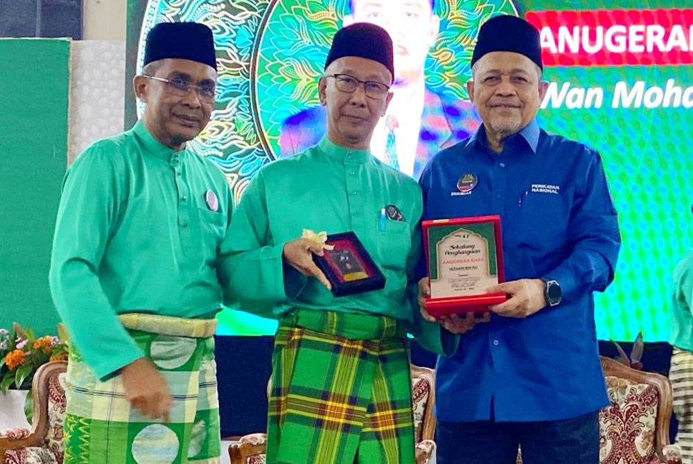 Shahidan (kanan) menyampaikan anugerah kepada perwakilan Pas semasa hadir merasmikan Mesyuarat Agung Tahunan Pas Kawasan Kota Bharu kali ke-56 di Kota Bharu.