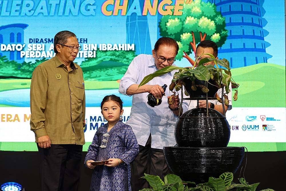 Anwar menyiram pokok Periuk Kera bagi menyempurnakan gimik perasmian Hari Air Sedunia 2023 di Stadium Indera Mulia pada Sabtu. - Foto: Bernama