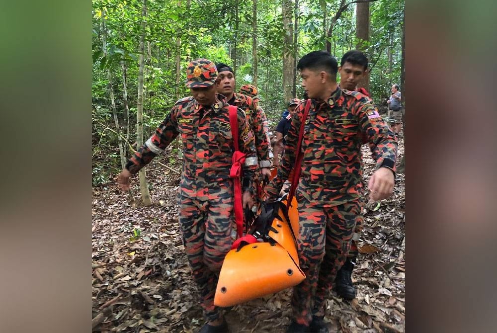 Anggota bomba membawa turun wanita warga emas yang patah kaki kanan selepas terjatuh ketika mendaki Gunung Lambak pada Sabtu. - Foto Bomba