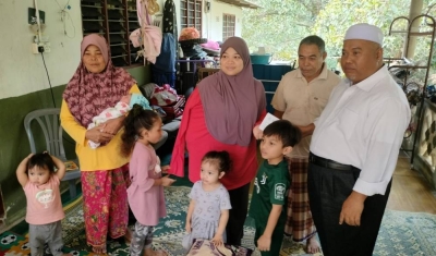 Siti Hafizoh (tiga kanan) bersama lima anak dan kedua ibu bapa menerima kehadiran Ahmad Mustaqim di rumah mereka di Baling, Kedah.