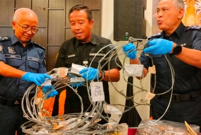 Abdul Kadir (tengah), Acryl Sani (kanan) dan Zazuli menunjukkan rampasan digunakan selepas mesyuarat OBK di Taman Negara Kuala Tahan, Jerantut pada Ahad.