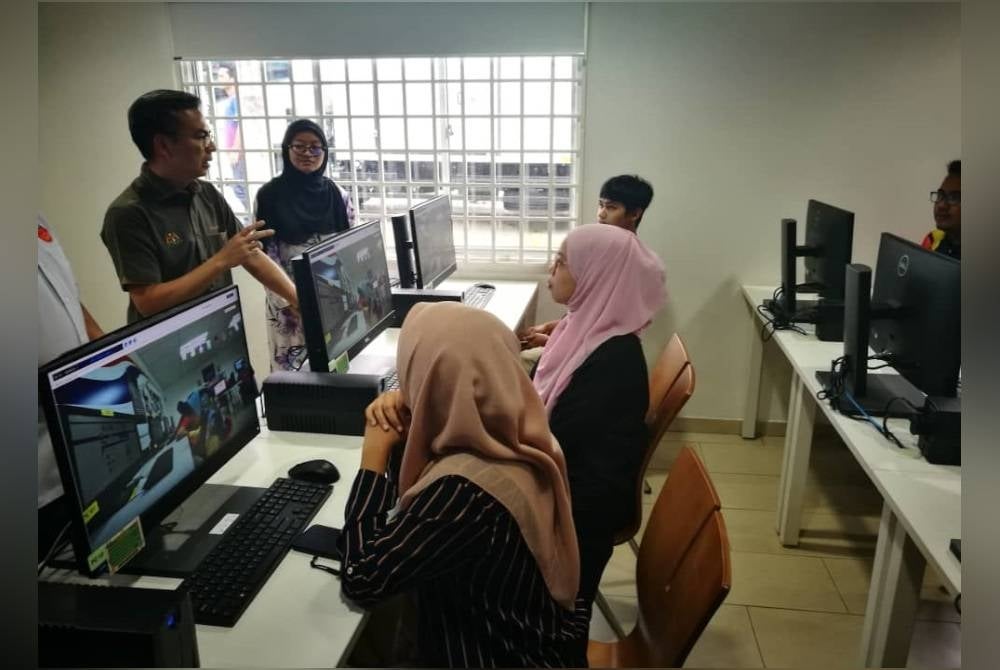 Fahmi berkata sesuatu kepada orang ramai ketika melawat PEDi, Kampung Sungai Tiram pada Isnin.