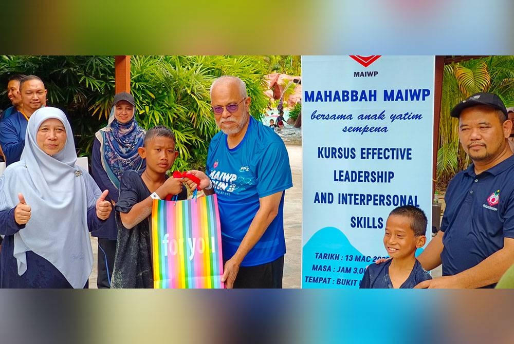 Zainal Abidin (tiga dari kanan) menyerahkan hadiah kepada salah seorang anak yatim yang memenangi sukaneka yang dianjurkan MAIWP pada Isnin.