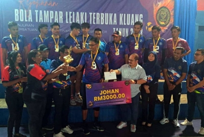 Shamsul Iskandar (tengah) menyampaikan hadiah utama kepada pasukan MTD Volley yang menjadi juara Kejohanan Bola Tampar Lelaki Terbuka Kluang 2023 Piala Madani di Stadium Tertutup Kluang, Kluang pada Ahad.