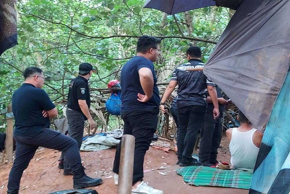 Tian Soon (kiri), bersama anggota AADK ketika menyertai serbuan di 'port bakau' berkenaan pada Isnin.