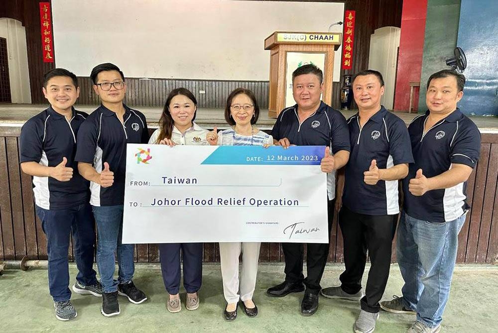 Yeh (empat dari kiri) menyampaikan cek sumbangan bantuan kemanusiaan kepada mangsa banjir di Johor.