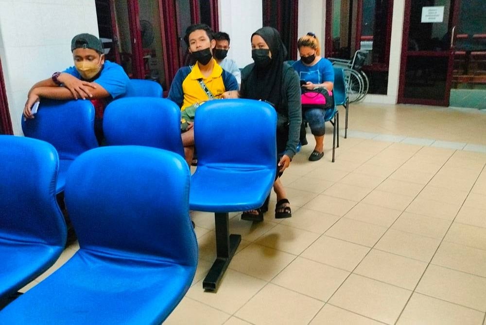 Mohd Faiz (dua dari kiri) bersama isteri ketika membawa bayi mereka berusia tujuh bulan ke Klinik Kesihatan Peringgit, Melaka pada Selasa.