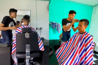 Muhammad Fikri menggunakan meja untuk memudahkan kerja menggunting rambut pelanggan.